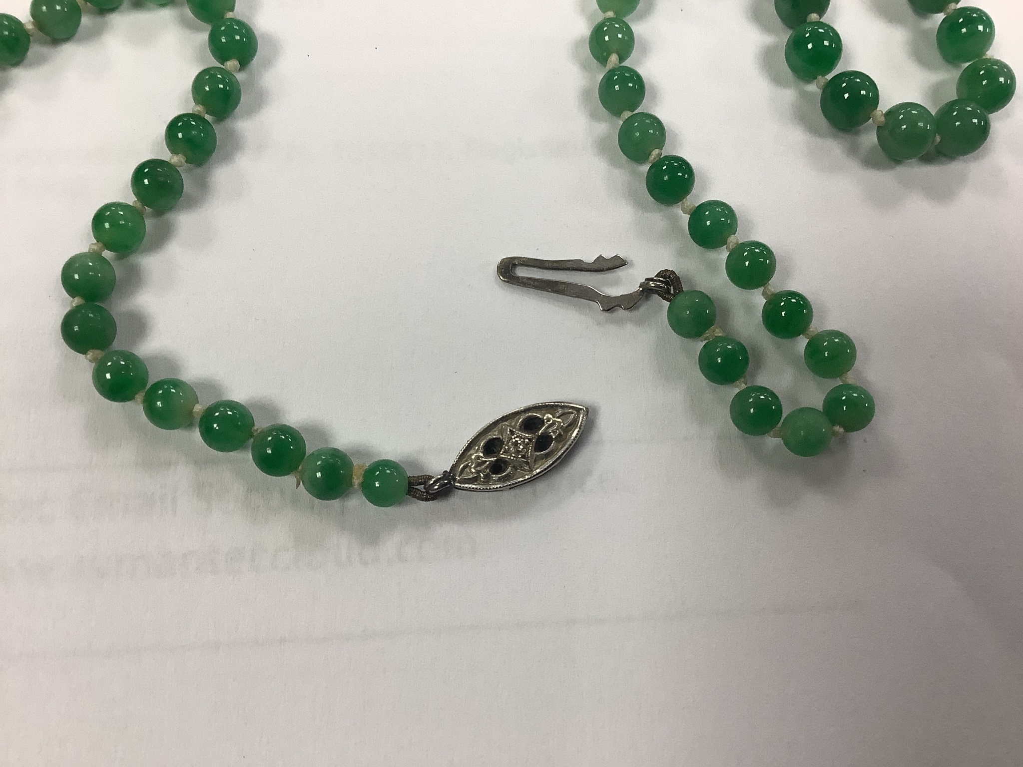 A graduated jade bead necklace with diamond set clasp stamped 9ct, 50cm